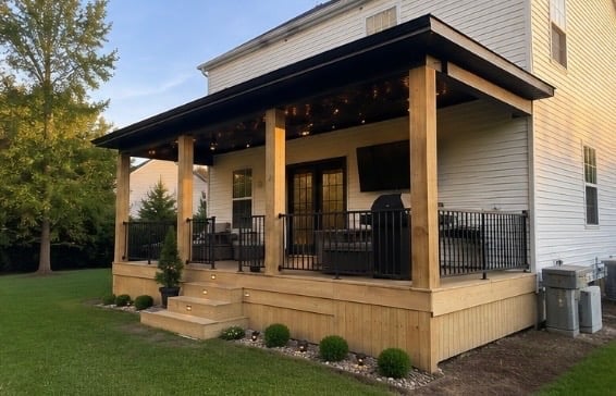 Residential house with a wooden deck porch featuring black metal railings and wooden support posts